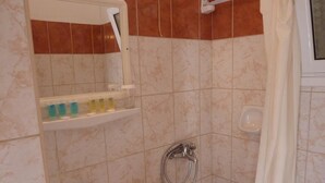 Ein Badezimmer mit Waschbecken, Spiegel, Dusche und Handtuchhalter.