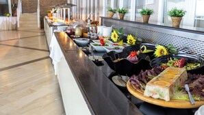 A buffet with various dishes and a long counter. - Oasis (Corfu)
