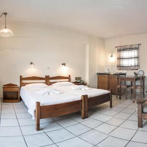 A bedroom with a wooden bed, bedside tables, a desk, and a chair. - Yiannis (Karpathos)