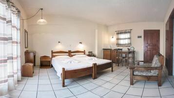 Ein Schlafzimmer mit Bett, Nachttischen, einem Schreibtisch, einem Stuhl und einem Fenster mit Vorhängen.