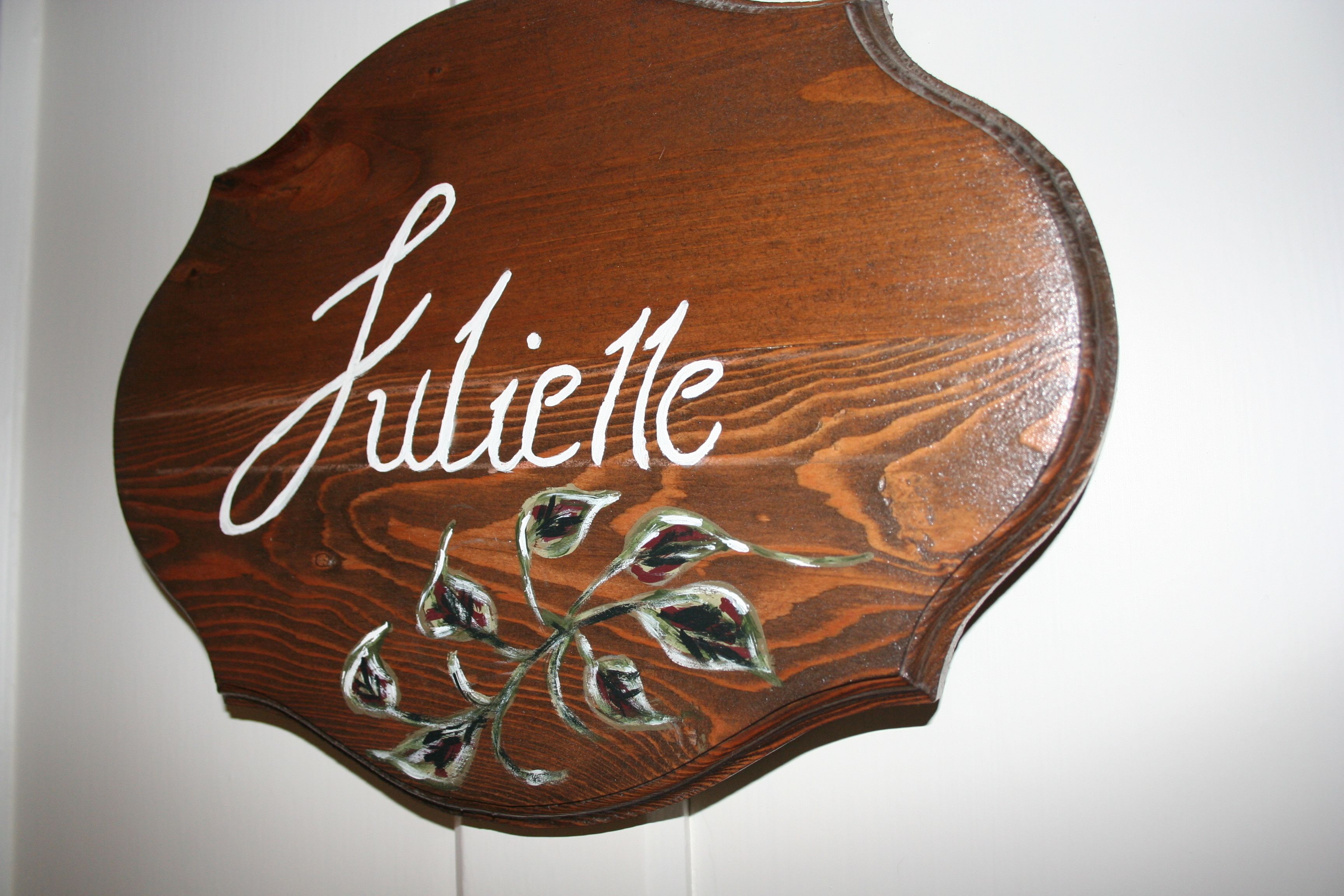 Un letrero de madera con el nombre 'Juliette' y hojas decorativas.