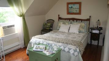 A bedroom with a wooden bed, a green nightstand, a window with curtains, and a painting on the wall.