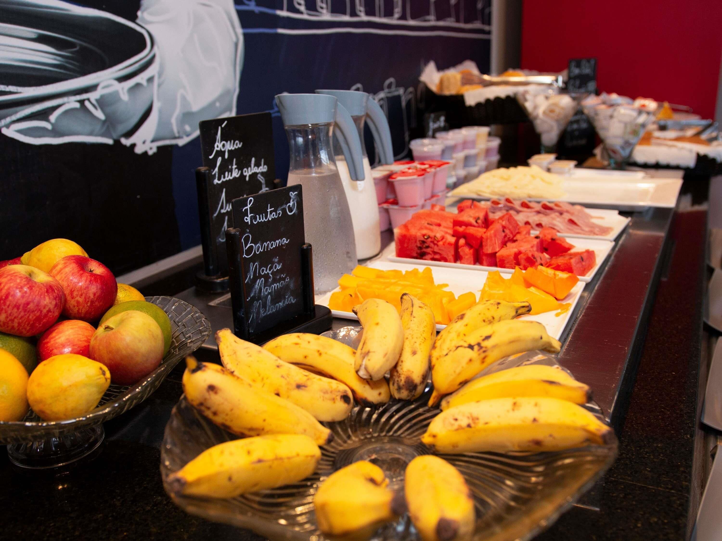 A buffet with fruits and a sign indicating available items.