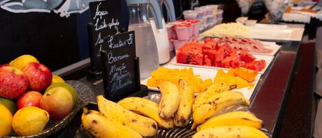 A buffet with fruits and a sign indicating available items.