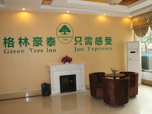 A reception area with a sign for Green Tree Inn and a slogan 'Just Experience'. - Green Inn Huainan Tianjiaan District Wanda Plaza Express Hotel (Huainan)