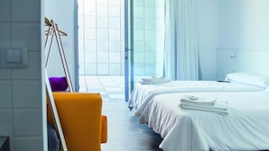 Une chambre d’hôtel avec deux lits, une grande fenêtre et une vue sur l’extérieur.