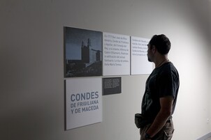 Una persona de pie frente a un panel informativo.