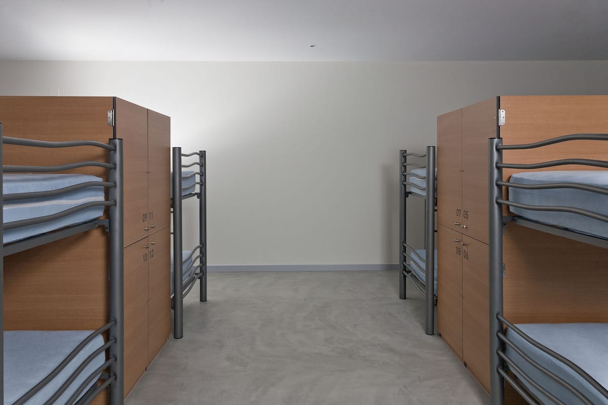 Ein Zimmer mit Etagenbetten und Holzschränken.