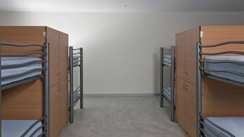 Una habitación con literas y armarios de madera.