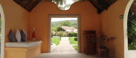 A covered outdoor area with a pathway leading to a garden.