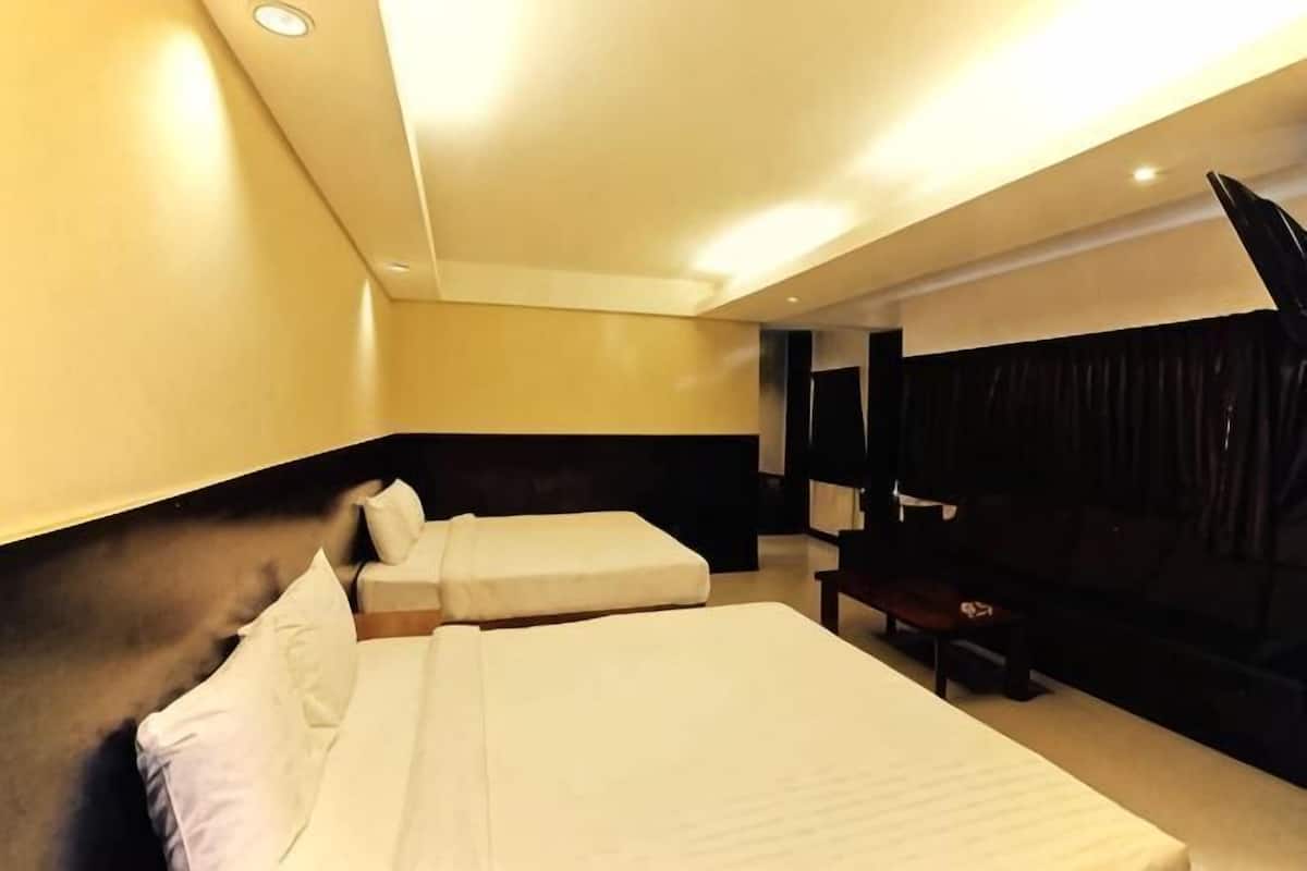 Une chambre d’hôtel avec deux lits, un bureau et une grande fenêtre.