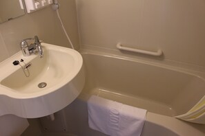 Une salle de bain avec un lavabo blanc, une baignoire et une serviette accrochée au mur.
