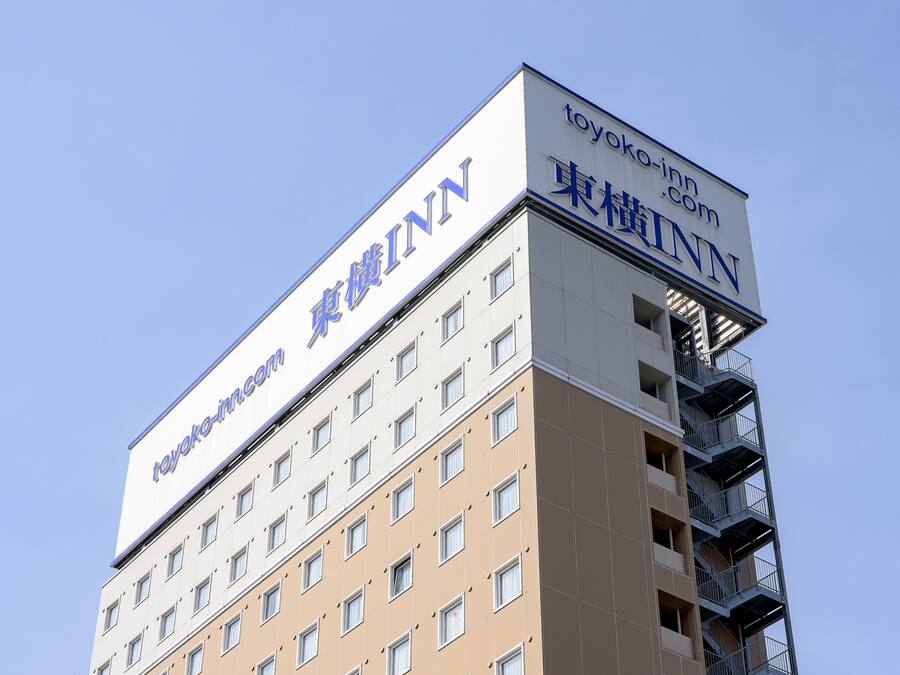 En flervåningsbyggnad med skyltar för ”toyoko.com” och ”toyokoinn.com”.