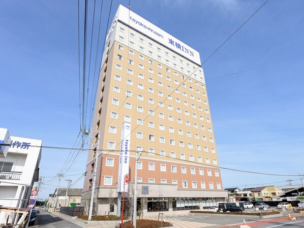 Et hotel i flere etager med tydelig skilt for 'Toyoko Inn' og et skilt, der angiver 'Parkering forbudt'.