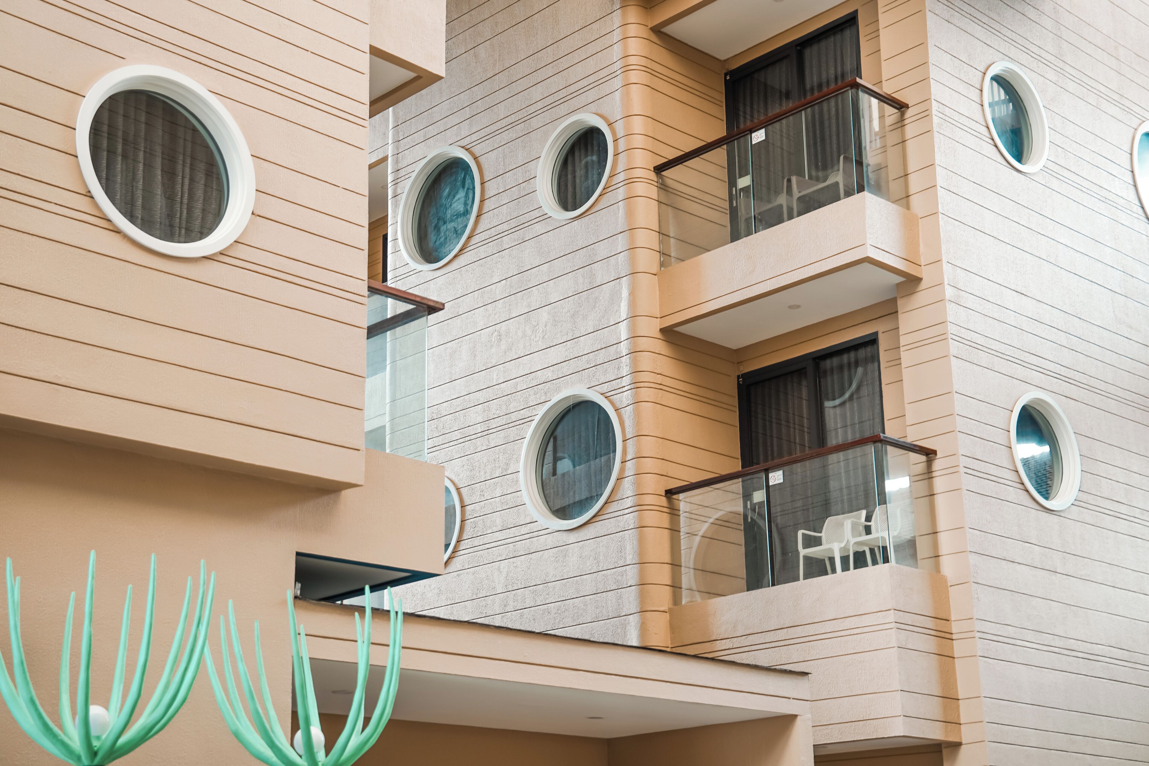 Een modern gebouw met meerdere balkons, ronde ramen en een uniek architectonisch ontwerp.