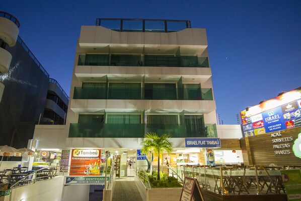 Un edificio de varios pisos con diseño moderno, que cuenta con balcones y ventanas amplias.