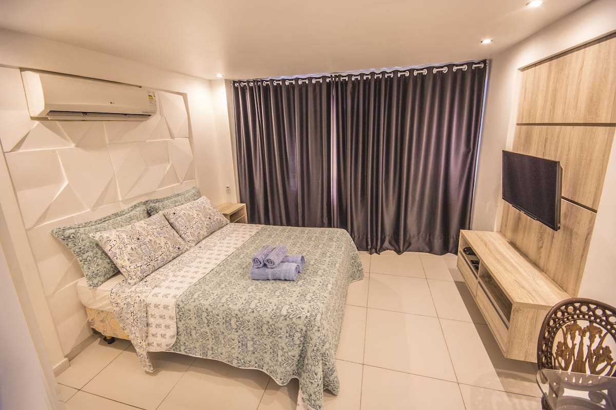 luxury studio suite, 1 bedroom, kitchen, partial sea view | blackout curtains, soundproofing, iron/ironing board, free wifi