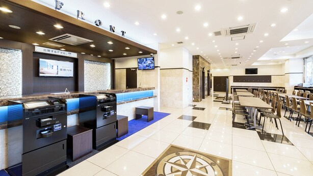 A modern hotel lobby with a reception desk, seating area, and a large dining space. - Toyoko Inn Tsu-eki Nishi-guchi (Tsu)