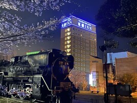 Una estación de tren con un edificio grande al fondo, que dice 