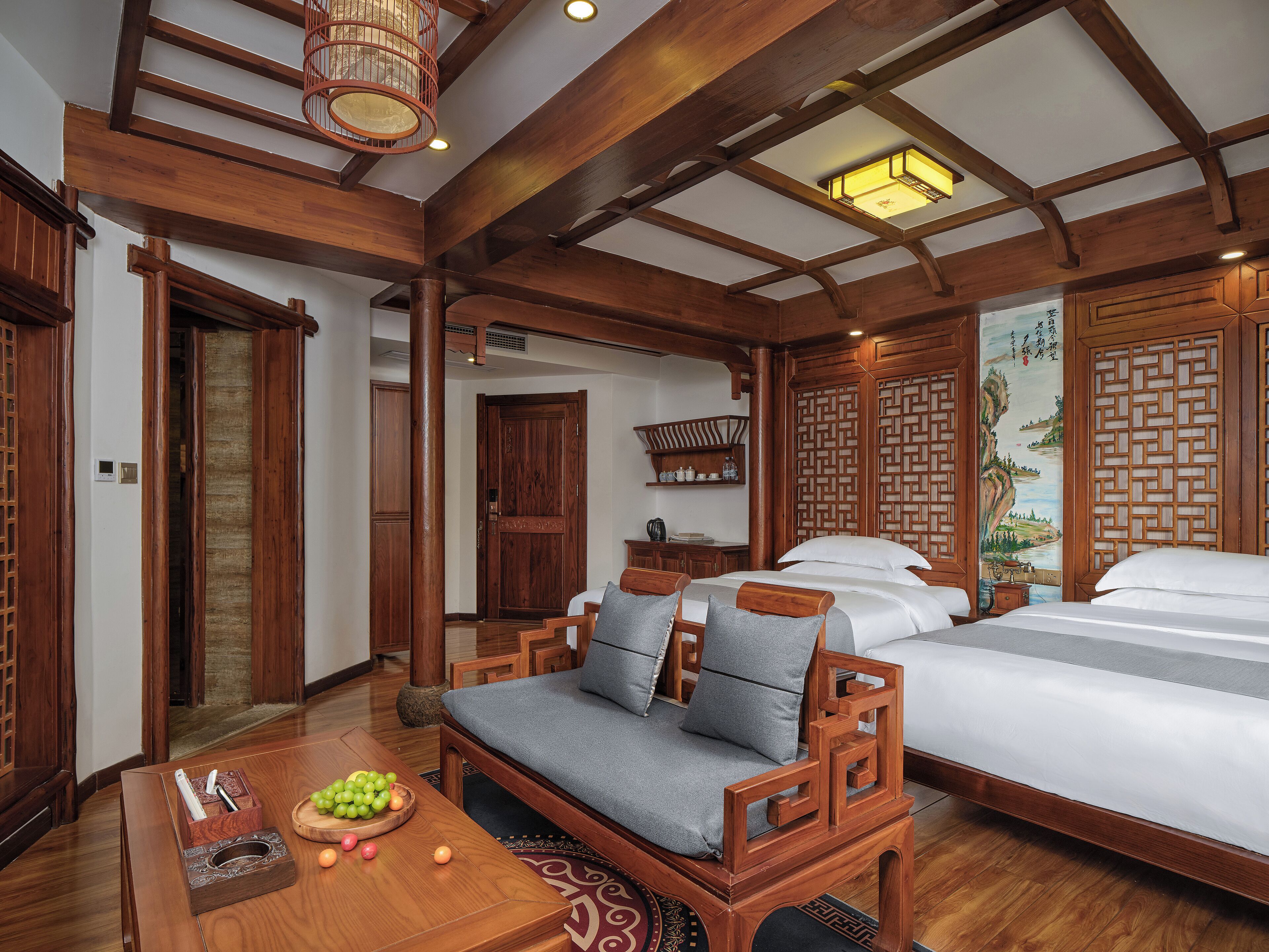 Una habitación de madera tradicional con cama, sofá y mesa de comedor con frutas.