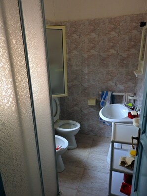 A bathroom with a toilet, sink, and mirror. - Studio on a farm near the sea (Siniscila)