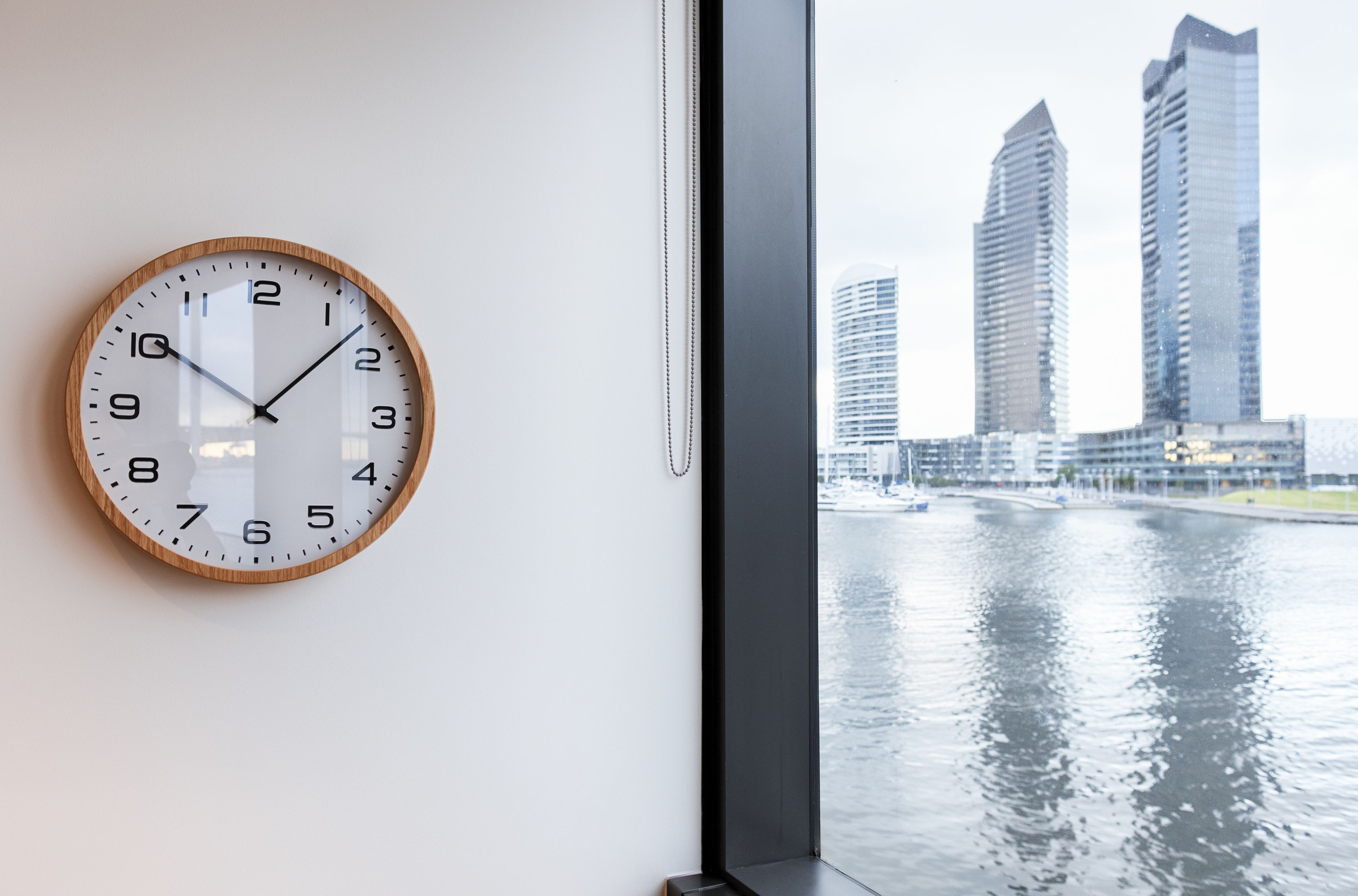 Un orologio a parete con vista sulla città attraverso una finestra.