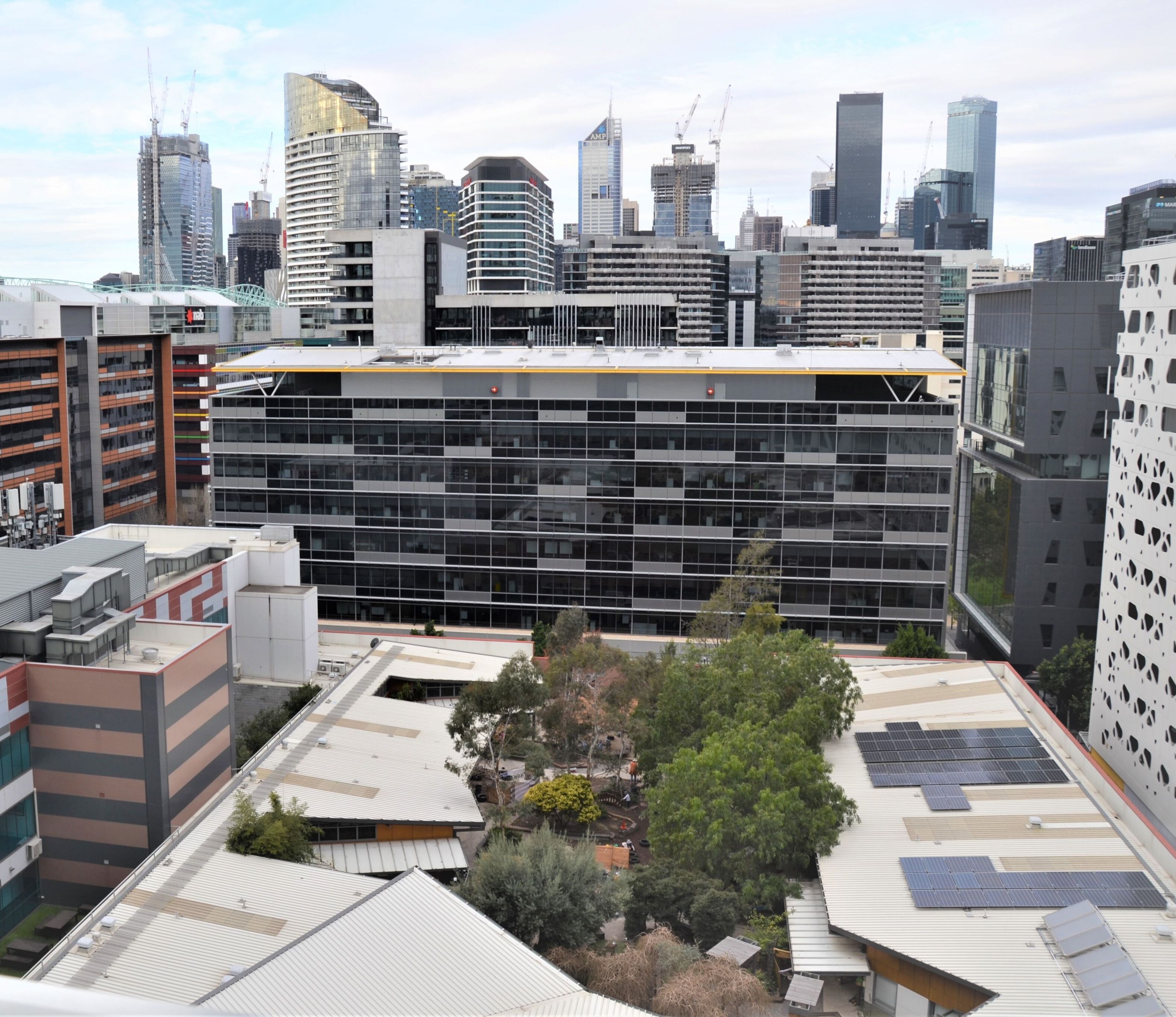 A modern building with a flat roof, surrounded by other high-rise buildings.