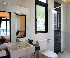 A modern bathroom with a large mirror, a sink, a toilet, and a shower area. - Water Ripple B&B (Shoufeng)