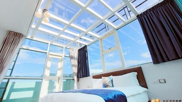 A hotel room with a large skylight, a bed, and curtains. - Water Ripple B&B (Shoufeng)