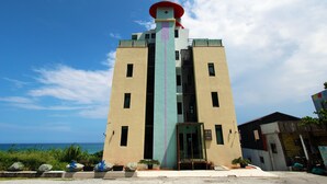 A tall, beige building with a red roof and a central vertical feature. - Water Ripple B&B (Shoufeng)