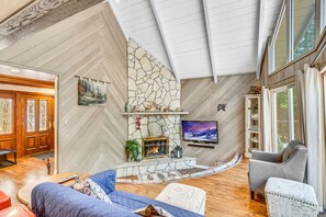 A cozy living room with a stone fireplace, comfortable seating, and a television. - FamilyRetreat, IndoorSpaTub, NewAC, 5mins walk2village, LakeAccess, Sleep15 (Lake Arrowhead)