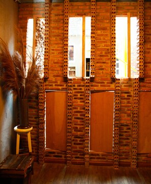 Une pièce avec un mur en briques, des portes en bois et une fenêtre.