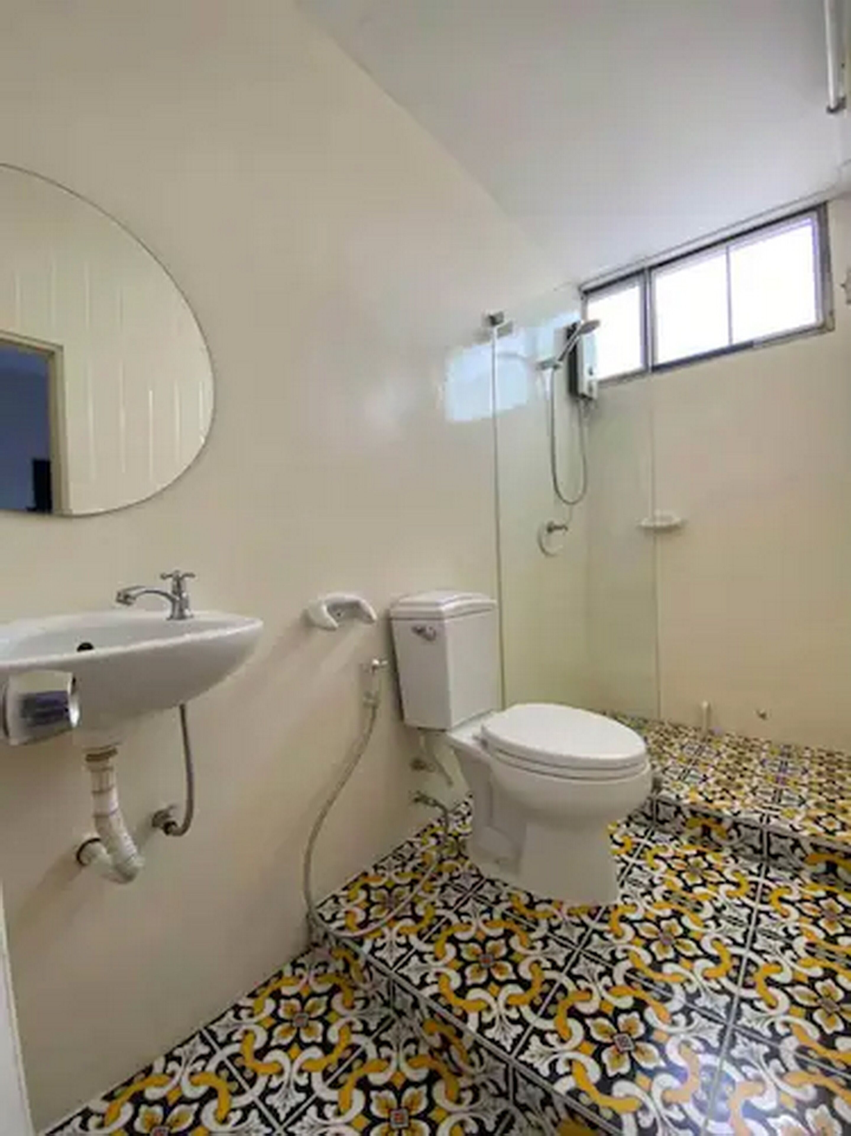 Une salle de bain avec des toilettes, un lavabo et une douche.