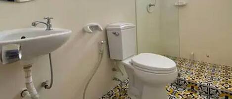 Une salle de bain avec des toilettes, un lavabo et une douche.