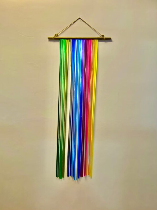 Una pared con una barra horizontal y cintas de colores colgando.
