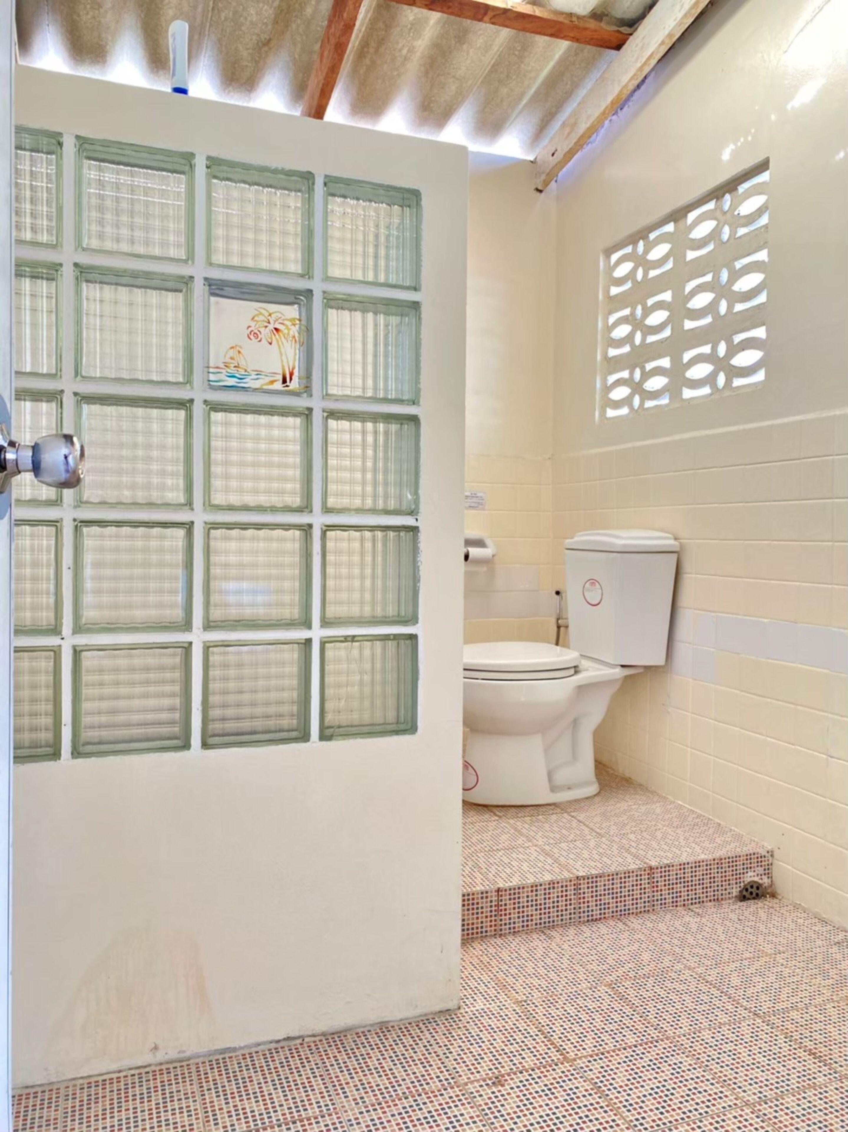 A bathroom with a toilet, a sink, and a shower area.