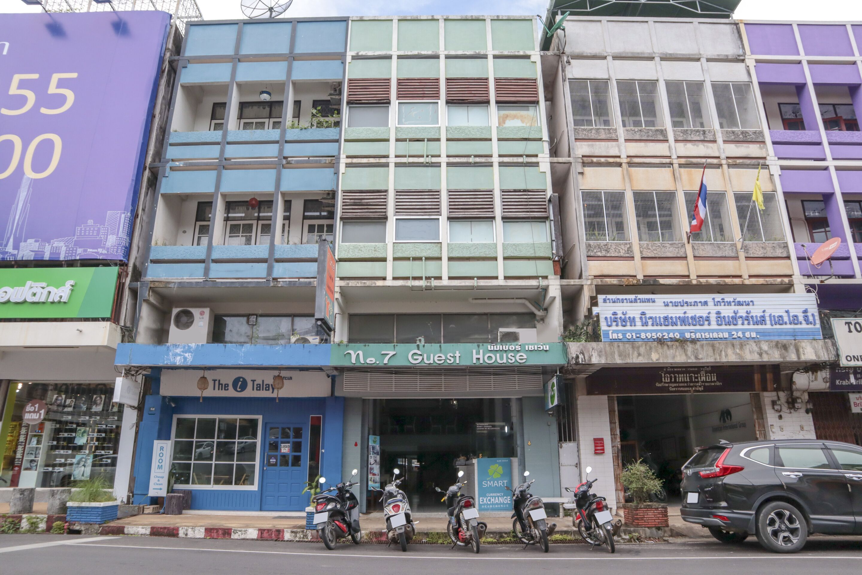 A building with a sign for 'No. 7 Guest House' and several motorcycles parked in front.
