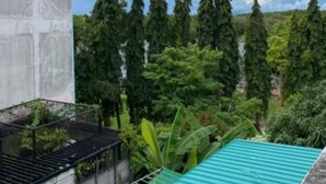 A building with a concrete exterior and a green roof. - No.7 Guesthouse (Krabi)
