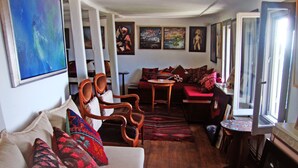 A cozy living room with a sofa, chairs, a small table, and a rug.