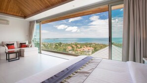 Un dormitorio moderno con una cama grande, un sofá y vistas al océano.