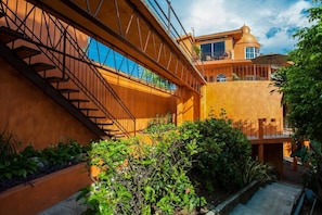 A modern building with a staircase, a balcony, and a garden area.