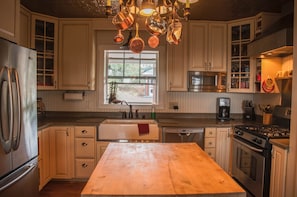Enjoy cooking in this well-equipped kitchen with a central island, refrigerator, dishwasher, stove, and oven.