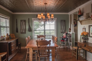 Enjoy meals in this stylish dining area with a wooden table, comfortable chairs, and a beautiful chandelier.