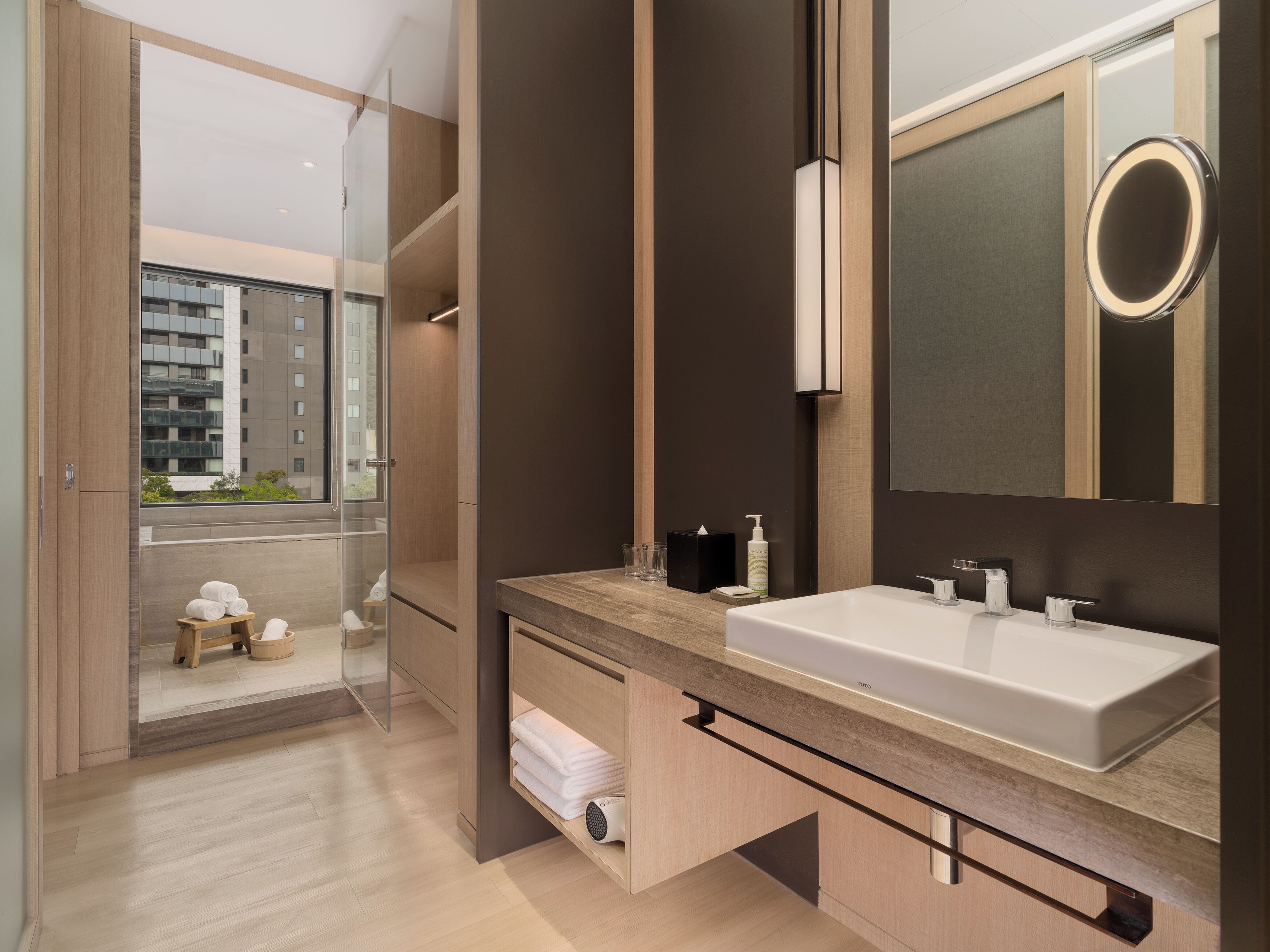 A modern bathroom with a large mirror, a sink, and a towel rack.