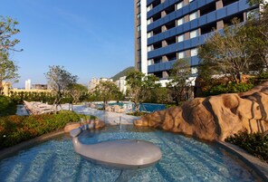 Una piscina al aire libre, sombrillas, sillones reclinables de piscina