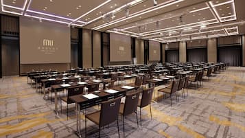 A conference room with rows of tables and chairs, equipped with microphones and projectors, at the JIAO XI HOTEL in Taiwan.