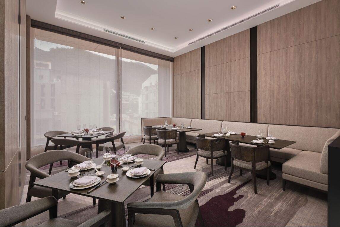 A modern dining area with round tables, chairs, and a sofa.