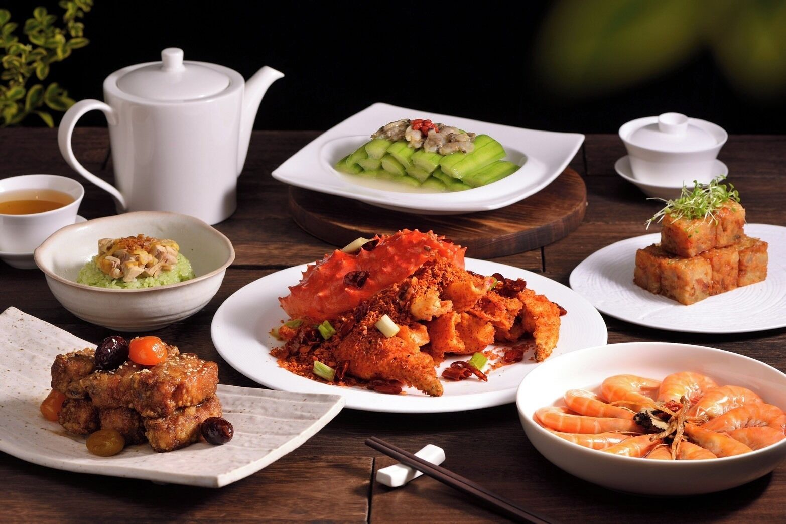 A variety of dishes including seafood, a teapot, and bowls on a table.