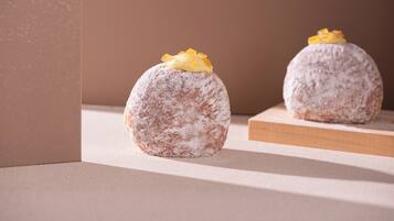 Two spherical pastries on a wooden surface with a plain background.