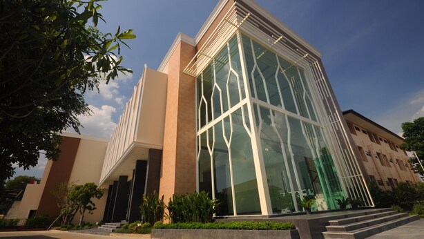 A modern building with large glass windows and a beige facade. - Srilamduan Hotel (Sisaket)